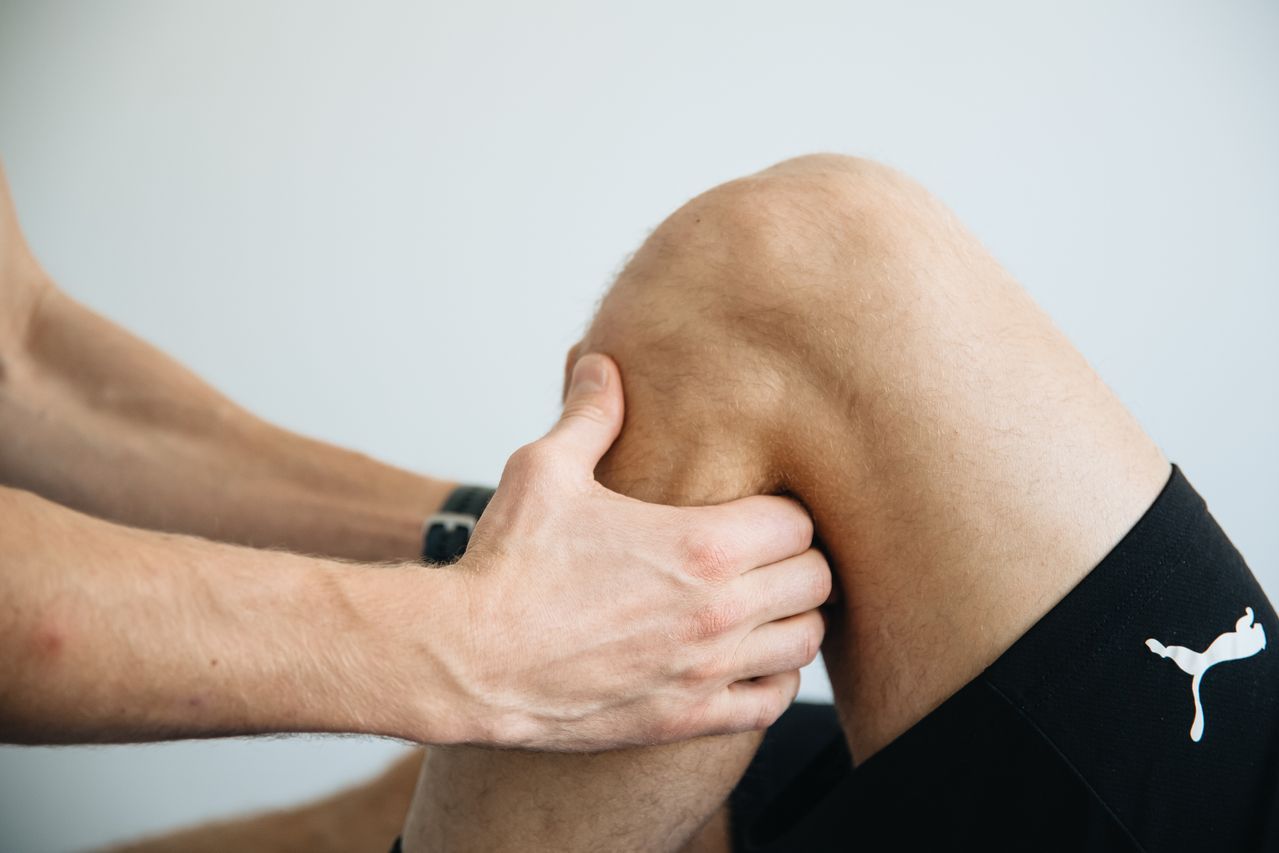 Footballer completing knee rehabilitation exercises with a physiotherapist