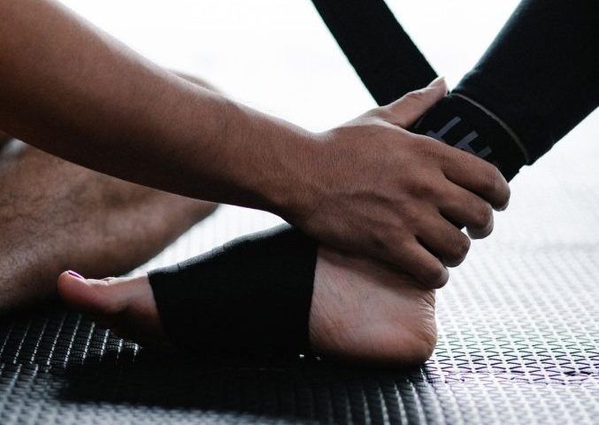 Physiotherapist strapping a football player's ankle